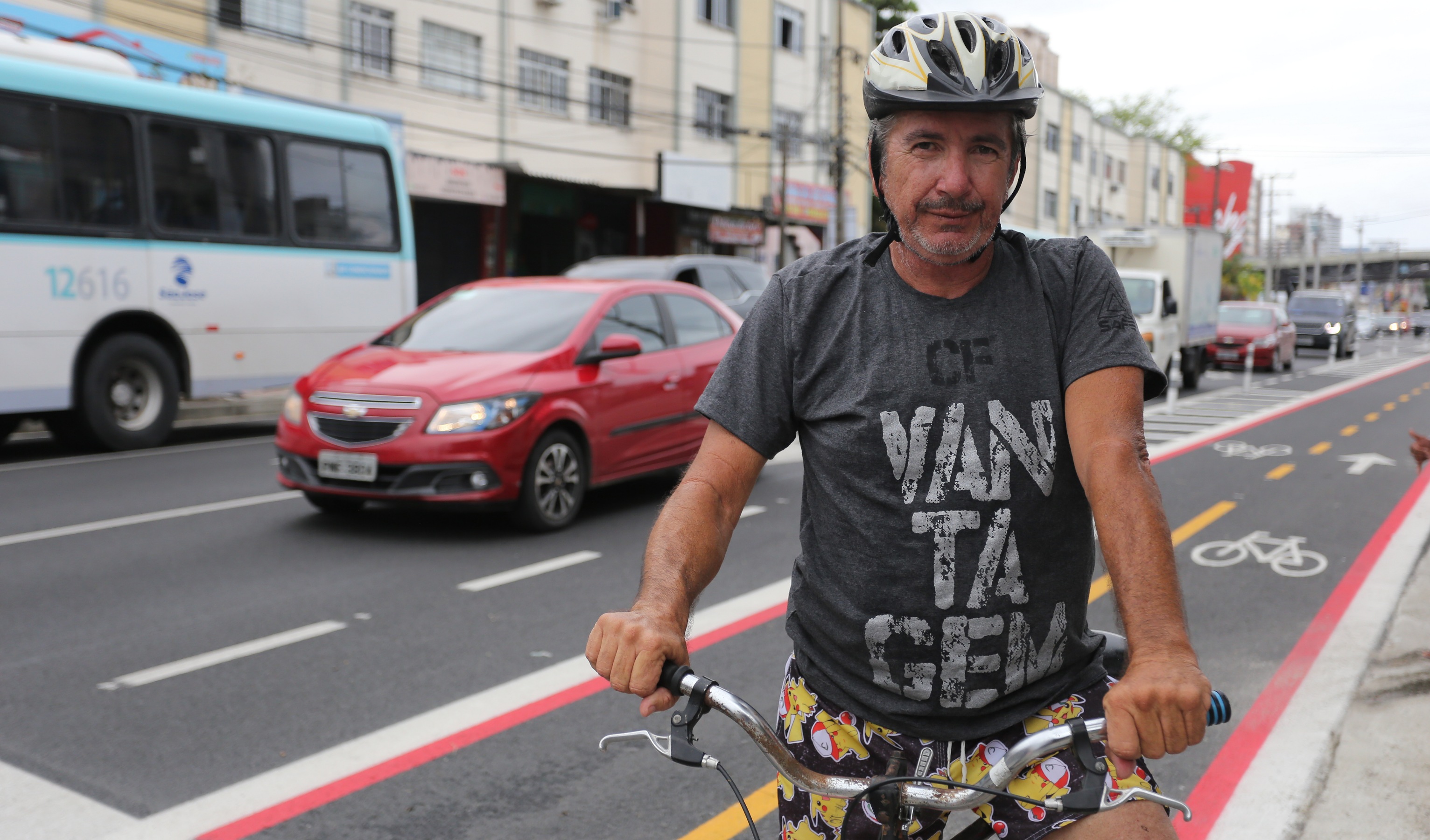 homem em bicicleta em avenida posando para a foto